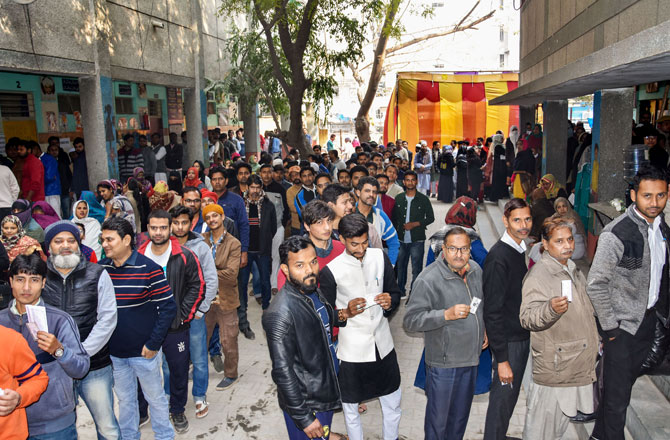 نئی دہلی کے باٹلا ہاؤس کے ایک پولنگ اسٹیشن پر، رائے دہندگان دہلی اسمبلی انتخابات کے لئے ووٹ ڈالنے کیلئے قطار میں کھڑے ہیں۔ تصویر : پی ٹی آئی