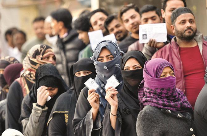 مسلم خواتین اپنے شناختی کارڈ دکھاتے ہوئے ۔ تصویر : پی ٹی آئی