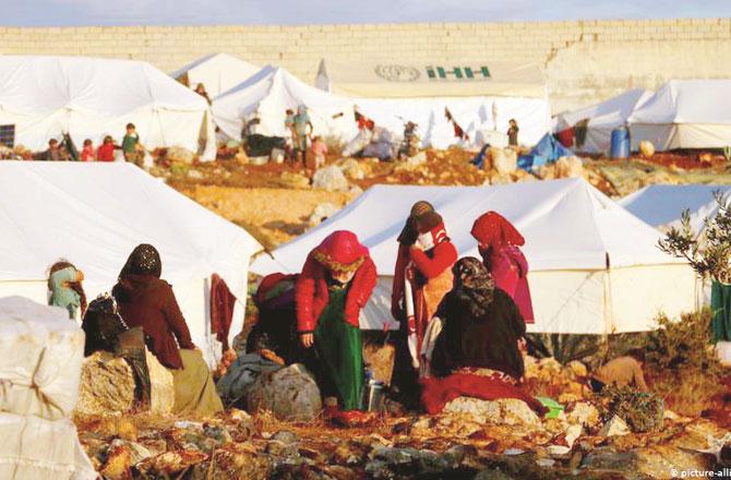 شام کے صوبہ ادلب میںبے گھر عورتیں اپنے خیموں کے باہر کام کاج میں مصروف ۔ تصویر : پی ٹی آئی