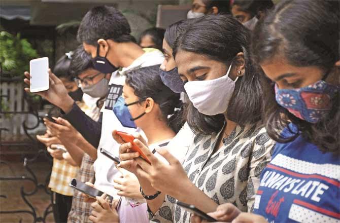Students checking results on their mobile phones. (File photo)