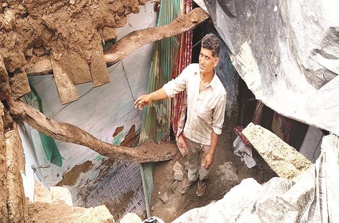 Arshad Beg showing his collapsed house.Picture:Inquilab