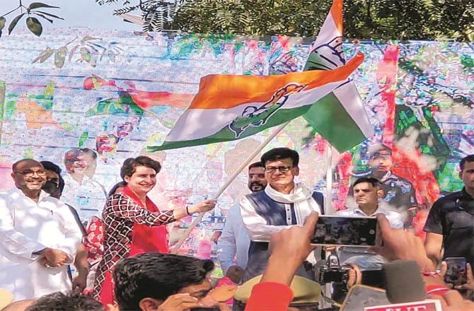 Priyanka Gandhi showing the green flag to a Portuguese pilgrim from Barabanki. (Photo: PTI)