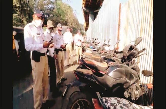 Traffic police officers take action against vehicles parked in the new parking lot.Picture:Inquilab