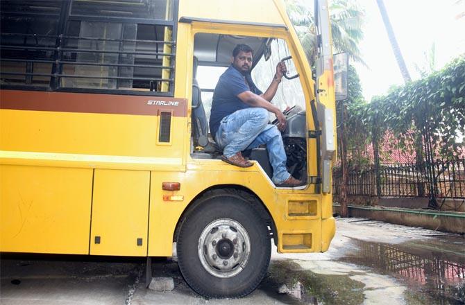 A driver is seen sitting in his school bus in the Lokhandwala Complex area.Picture:Inquilab