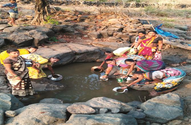 Tribal women collecting dirty water.