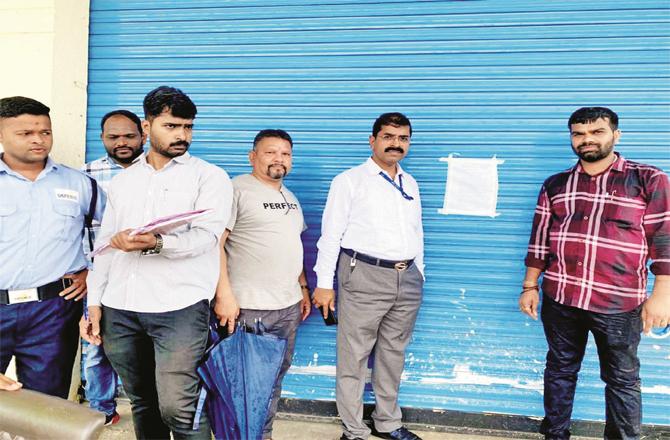 Revenue department officials can be seen sealing an illegal warehouse.