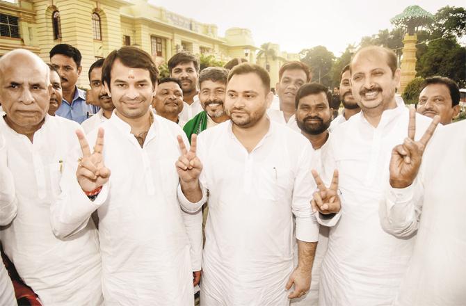 Deputy Chief Minister Tejashwi Yadav, his brother Tej Pratap Yadav and other leaders show victory sign after receiving vote of confidence. (Photo: PTI)