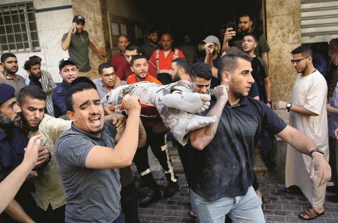 After the Israeli attack, local youths can be seen transporting a person buried in the rubble to the hospital.Picture:PTI/AP