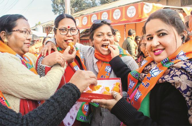 Women workers distributing sweets on BJP`s victory in Gujarat.