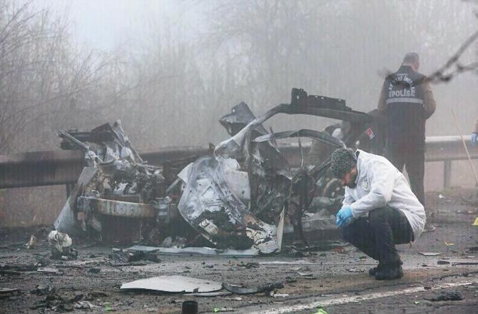 Turkish security officials inspect a vehicle destroyed in a bomb attack