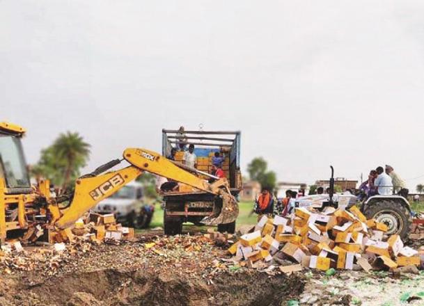 The confiscated liquor is being destroyed with the help of JCB. Picture:INN