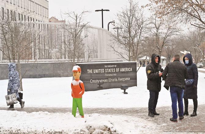 Some people are talking to a security official outside the US embassy in Ukraine