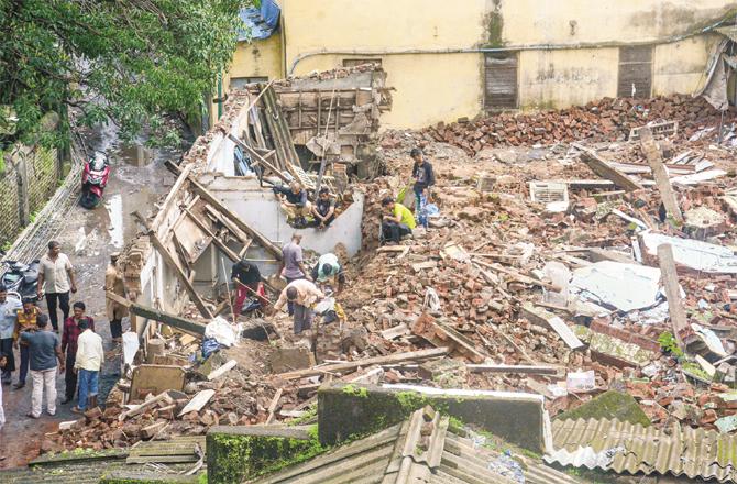 After the building collapsed on the house, local people are searching for essential items from the debris.