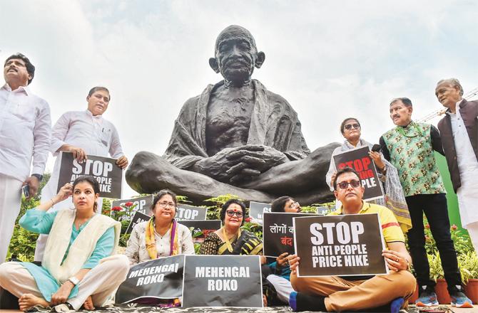 Members who have been suspended can be seen protesting in front of Gandhiji`s statue in the Parliament complex. (Photo: PTI)