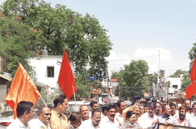 Shiv Sena members take a picture of Bal Thackeray and demonstrate in favor of Adho Thackeray.