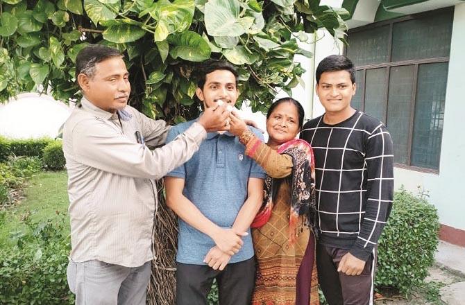CDS exam topper Himanshu eating sweets at the hands of his parents along with his brother..Picture:INN