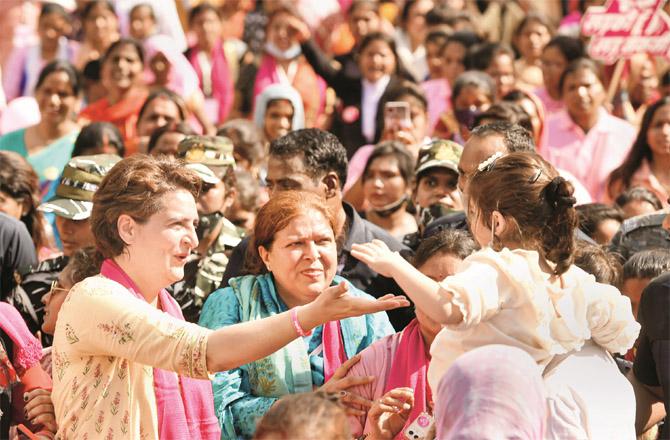 Priyanka Gandhi feeding a baby girl during a march in Lucknow. (PTI)