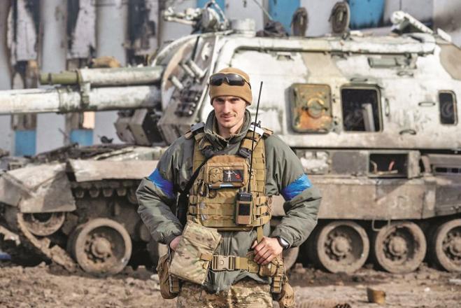 A Ukrainian soldier poses for a photo with a Russian tank.Picture:INN