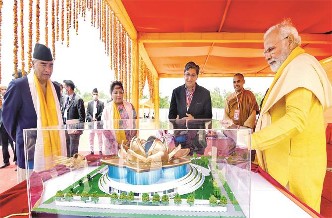 Prime Minister Modi looks at the model of cultural center being built in Nepal, Nepal`s Prime Minister Deuba (left) and his wife are also present