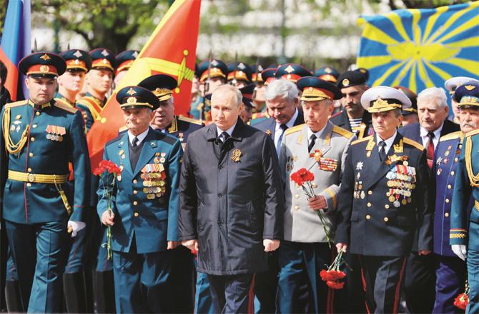 Russian President Vladimir Putin, accompanied by senior military officers, pays homage to the soldiers` memorial.