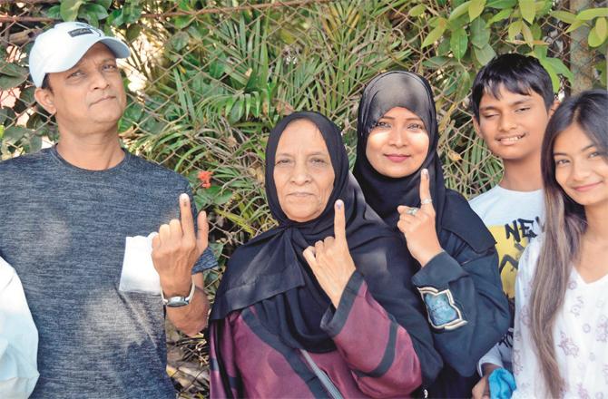 Voters of a family showing an inked finger after voting