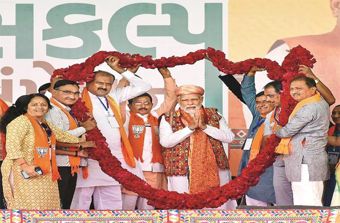 Prime Minister Narendra Modi surrounded by party workers after an election rally in Bhaunagar