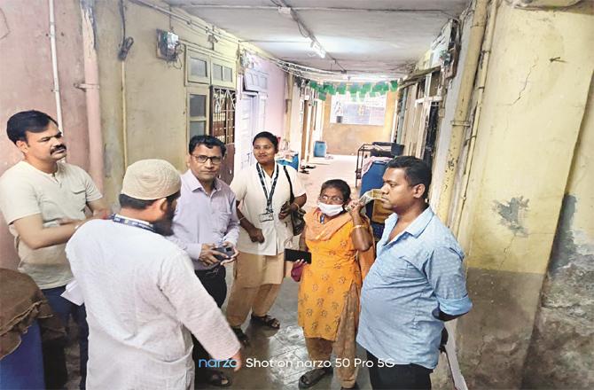 TMC officials surveying measles patients in a building.