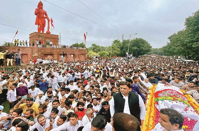 Akhilesh Yadav with his father`s body in Saifai. Crowds of party workers and mourners can also be seen on this occasion. (Photo: PTI)