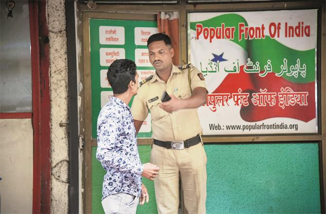 Police personnel can be seen posted outside the Popular Front of India office in Navi Mumbai. (PTI)