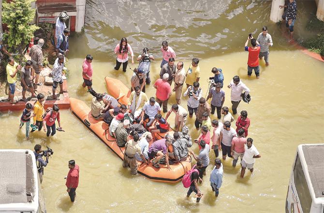 People trapped in the water are being taken to safety by a boat