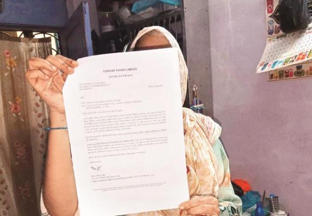 A woman from Mumbra showing a notice of Torrent Power Company. .Picture: Inquilab