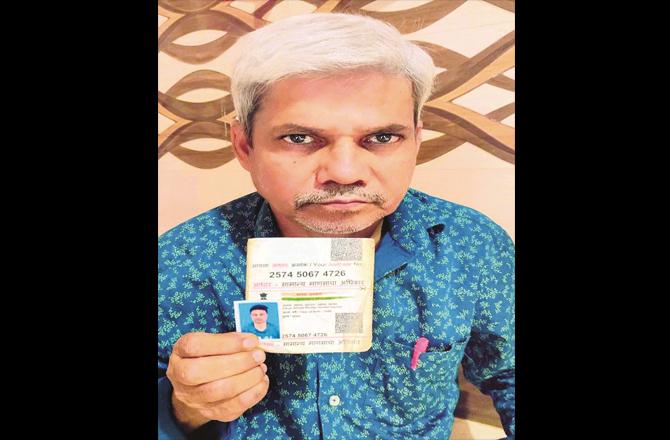 Father Mushtaq Ahmad Syed showing his son`s photo and Aadhaar card.