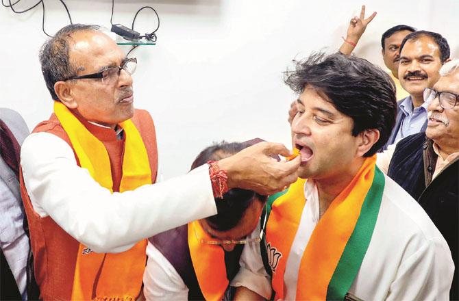Shivraj Singh Chauhan feeding sweets to Jyotraditya. Photo: INN