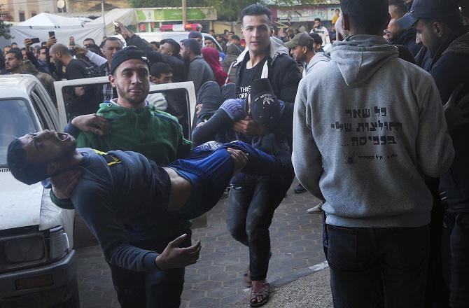 Palestinians carrying their injured comrade to the hospital. Photo: PTI