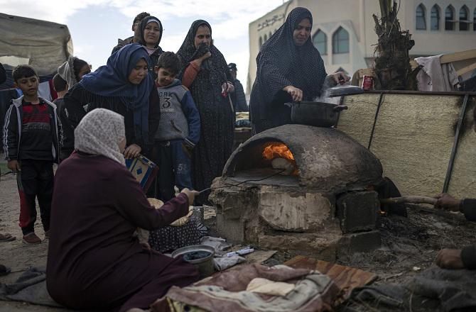 Displaced Palestinians stand for bread at the Rafah border. Photo: PTI