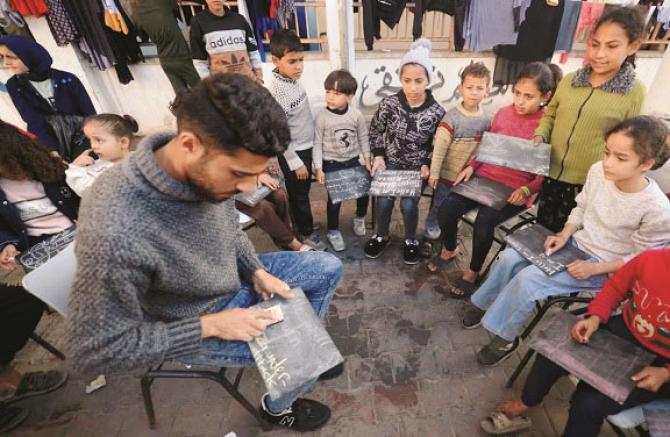 غزہ میں ملبے کے ڈھیر پر فلسطینی بچوں کو پڑھاتا ٹیچر طارق النبی 