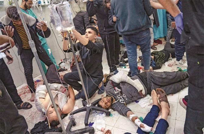 Injured people in Israeli attacks can be seen being treated in a hospital in Gaza. There is no space in the hospitals, so patients are being treated on the ground. Photo: Agency