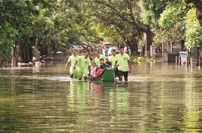 Relief workers taking people stranded in an area of Chennai to safety by boat. (PTI)