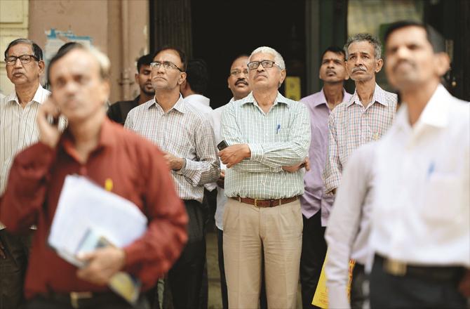 Retail investors and share agents can be seen staring at screens outside the BSE. File photo