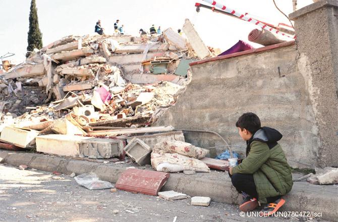 A child near a damaged building in an earthquake-hit area of Turkey.