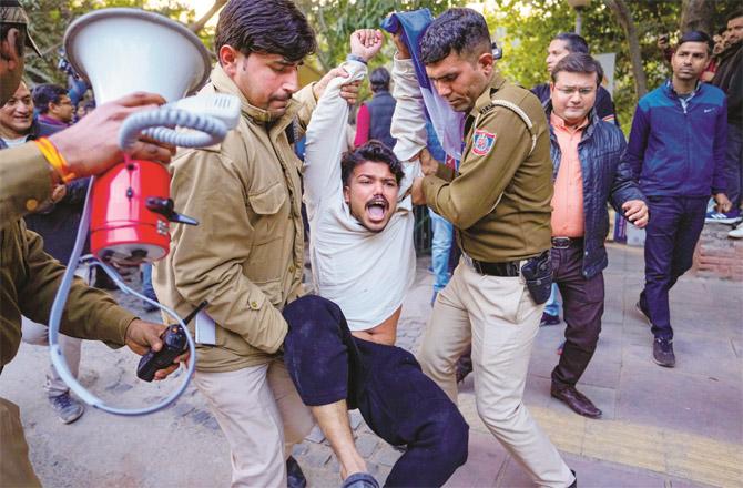 Police detaining a student at Delhi University. (PTI)