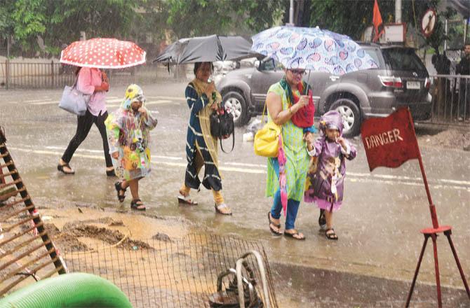 Pedestrians cross a road during monsoon rains in Mumbai. (Photo: Atul Kamble)