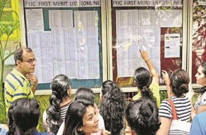 On the board of a college, female students are searching for their names in the first FYJC merit list.