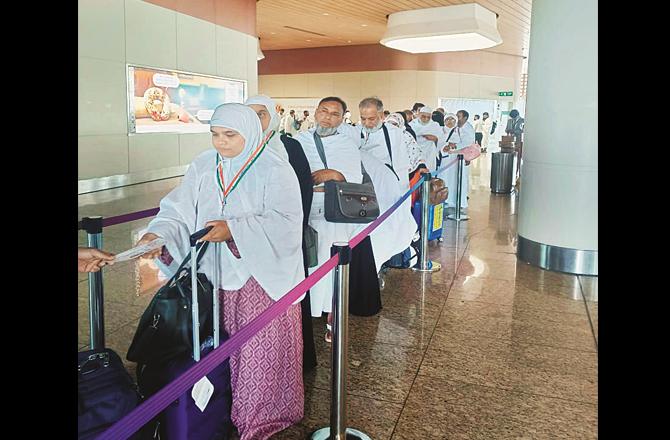 Pilgrims can be seen queuing at the Mumbai airport