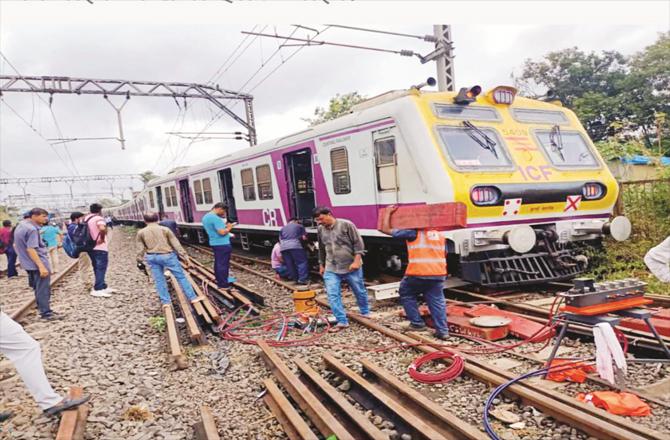 Railway employees trying to bring the coach of local train on track.