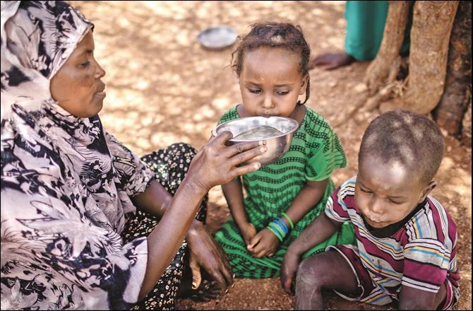 This photo is from Somalia, in which a mother gives water to her children. (Photo courtesy: UNICEF)