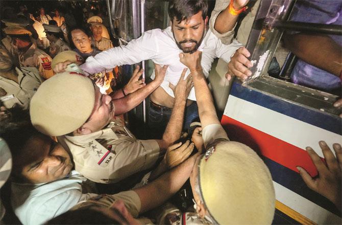 Congress workers at the Red Fort being pushed into a heavy police van by the Delhi Police. (PTI)