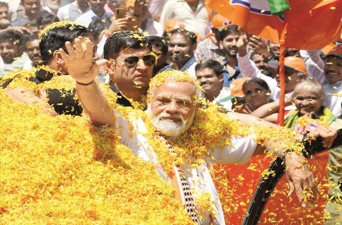 Prime Minister Modi responding to public reception during the road show in Mandya. (PTI)