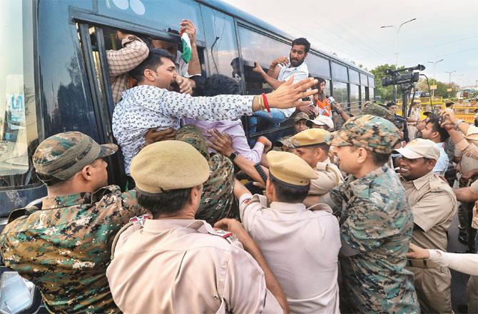 Youth Congress workers staged a protest outside the BJP office in Jaipur. In the picture below, the police are seen taking them into custody. (Photos: PTI)