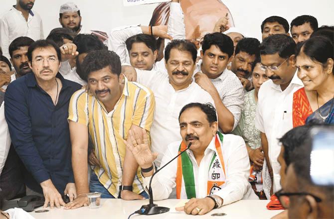 Jayant Patil, surrounded by NCP workers, addressing a press conference (PTI)